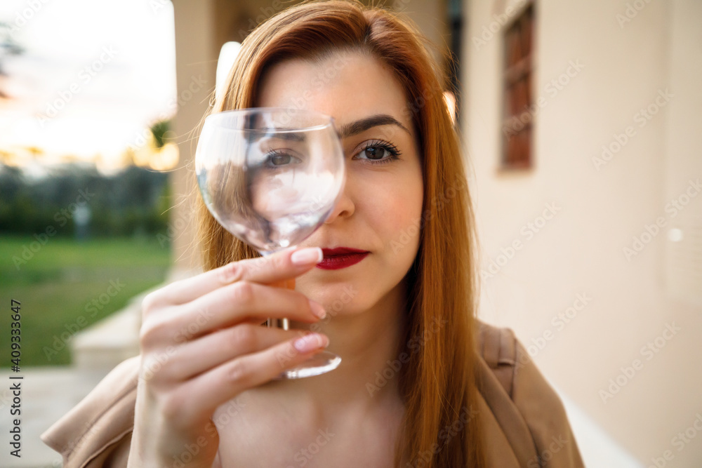 young beautiful red-haired girl holding a glass in her hands young beautiful red-haired girl holding a glass in her hands