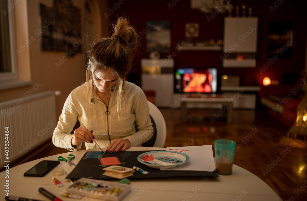 Fototapeta premium Girl doing crafts at home by night