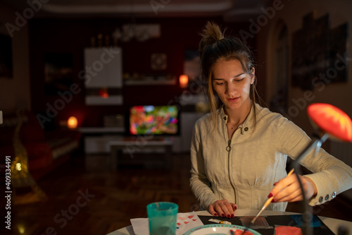 Girl doing crafts at home by night