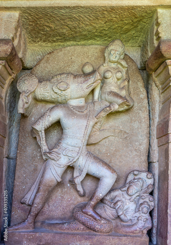 Aihole, Karnataka, India - November 7, 2013: Durga Gudi or Temple. Gray stone statue of Vishnu as Varaha avatar, boar,  with his foot on the snake Naga. photo