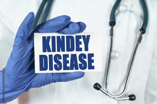 The doctor holds a business card that says - KINDEY DISEASE photo