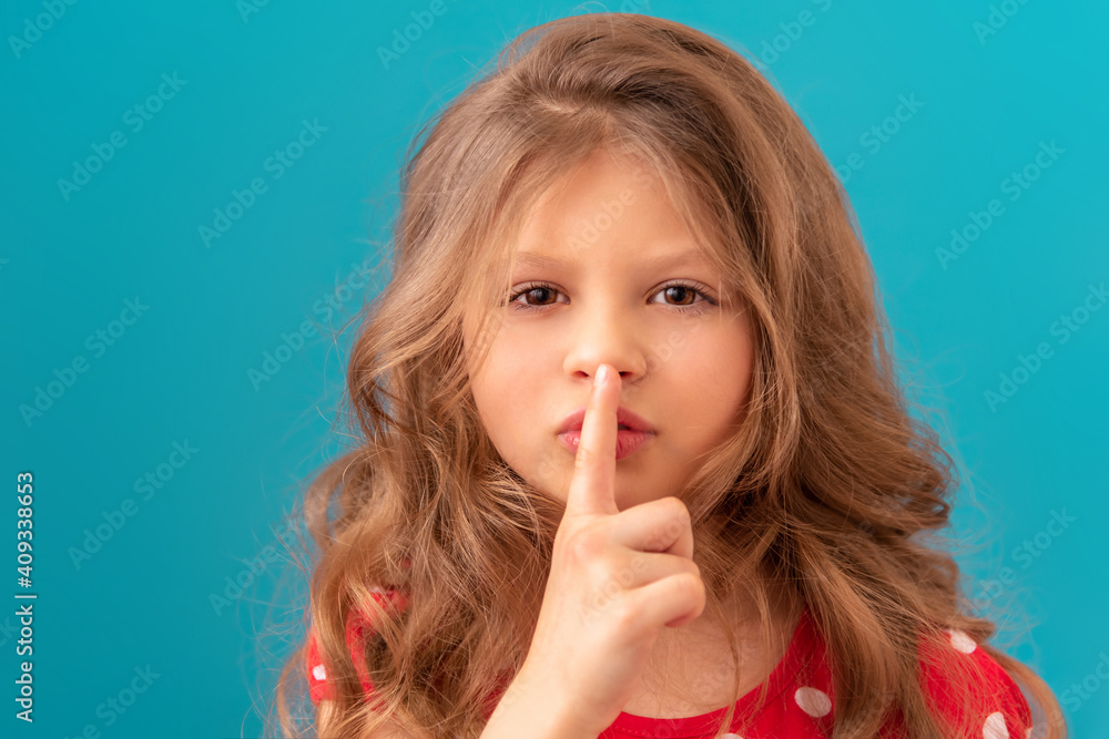 Little beautiful girl points her finger be quiet. Little beautiful girl points her finger be quiet.