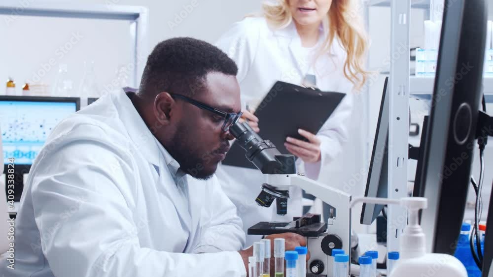 Professional team of scientists is working on a vaccine in a modern scientific research laboratory. Genetic engineer workplace. Futuristic technology and science concept. Professional team of scientists is working on a vaccine in a modern scientific research laboratory. Genetic engineer workplace. Futuristic technology and science concept.