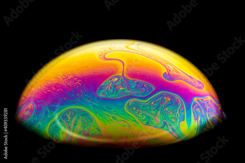 Macro picture of half soap bubble on black background. psychedelic color for a wallpaper or screensaver