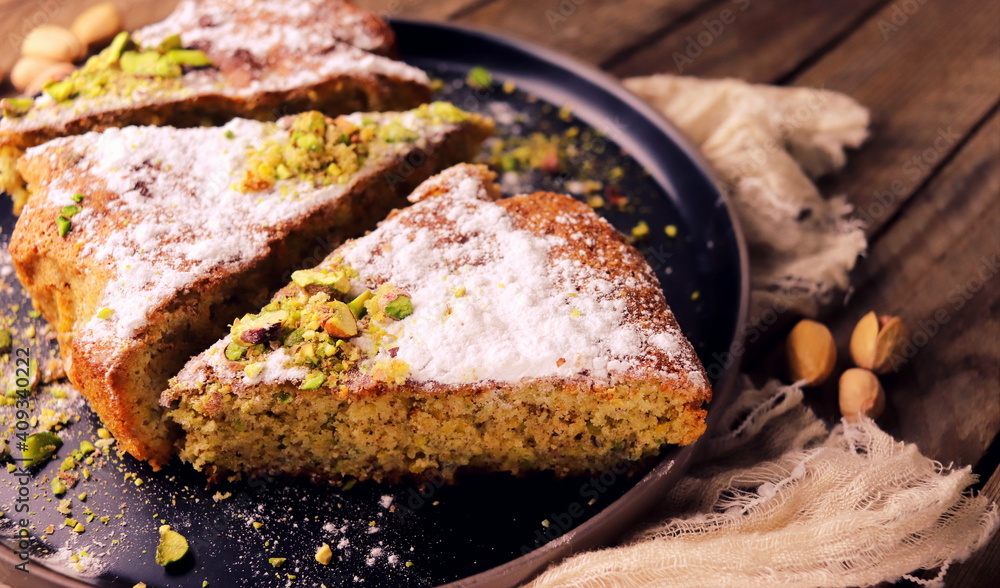 Homemade pistachio pie close-up in a black plate on a wooden table selective focus.