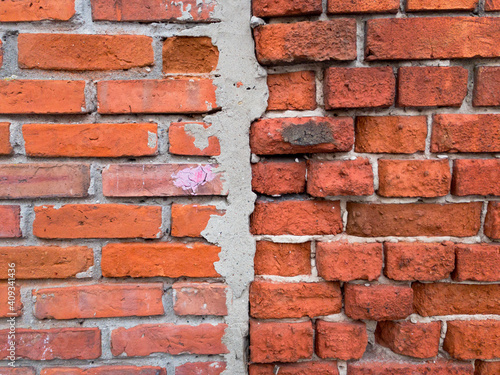 Old red brick wall meets old bricks wall. Divided 