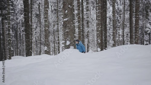 Slow motion shot of Professional athlethe cross country skier running on skis trough the frozeen forest covered in snow photo