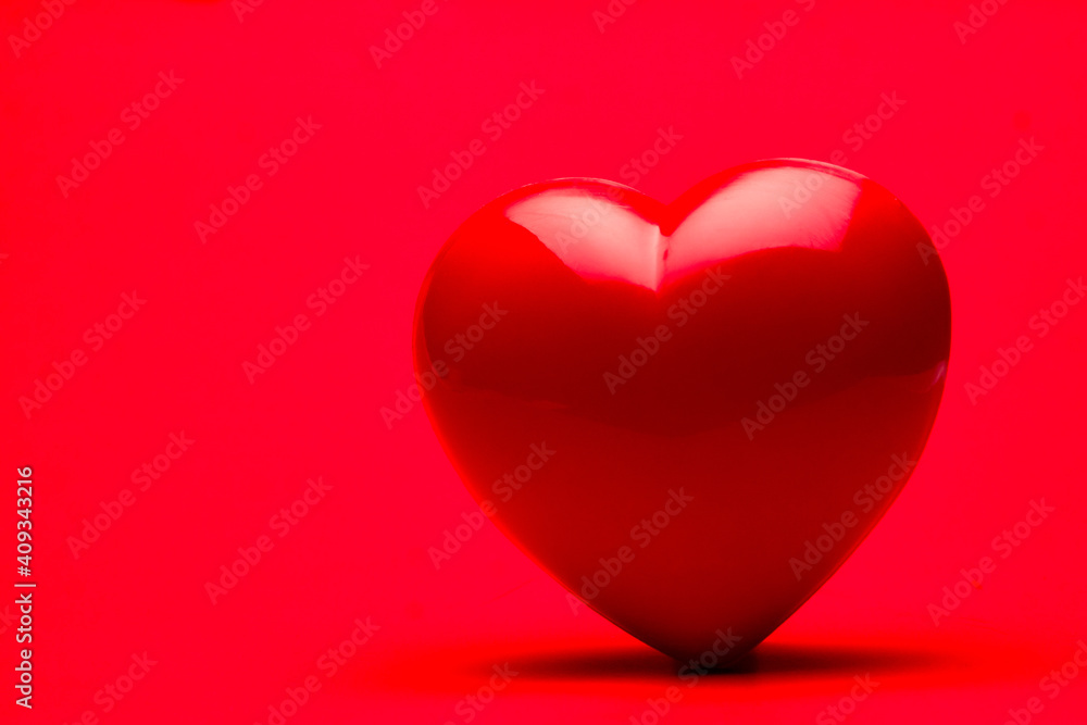 Red heart on red color background, Valentine's day greeting card, copy space for your text Red heart on red color background, Valentine's day greeting card, copy space for your text