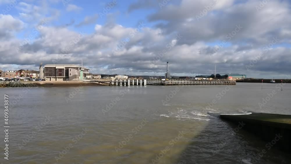 Video of Shoreham harbour and the RNLI Lifeboat Station next to the lighthouse on a clear and sunny day with dramatic cumulus cloud.