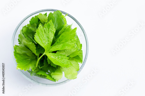 Chinese celery leaves in glass bowl on white