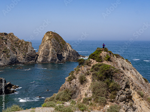 Man on top of cliff in beach during summer, in costa vicentina, alentejo, portugal