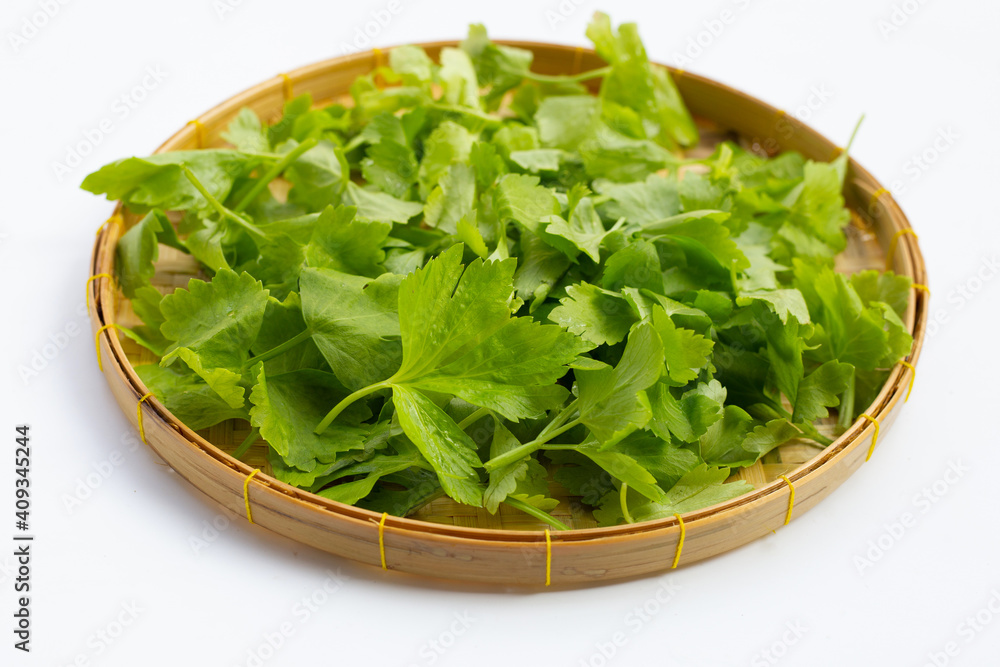 Chinese celery in bamboo basket on white Chinese celery in bamboo basket on white