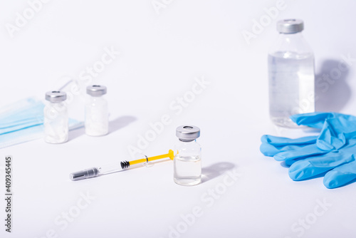 Doctor, researcher holds hands syringe in blue glove holding flu, measles, rubella or hpv vaccine and syringe with needle vaccination for human.