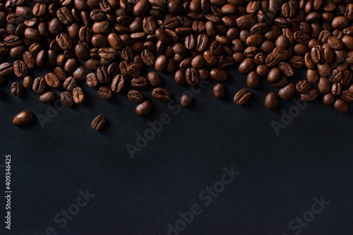 Fresh roasted coffee beans closeup on black stone background. Top view  flat lay with copy space