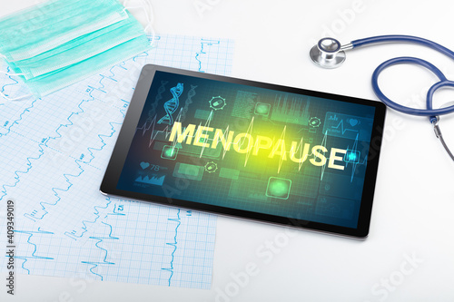 Tablet pc and medical stuff with MENOPAUSE inscription, prevention concept