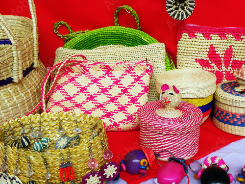 Wicker souvenirs: baskets, dolls, toys, earrings made from toquilla straw, vegetable fiber and painted with various colors at artisan market in Cuenca, Ecuador photo