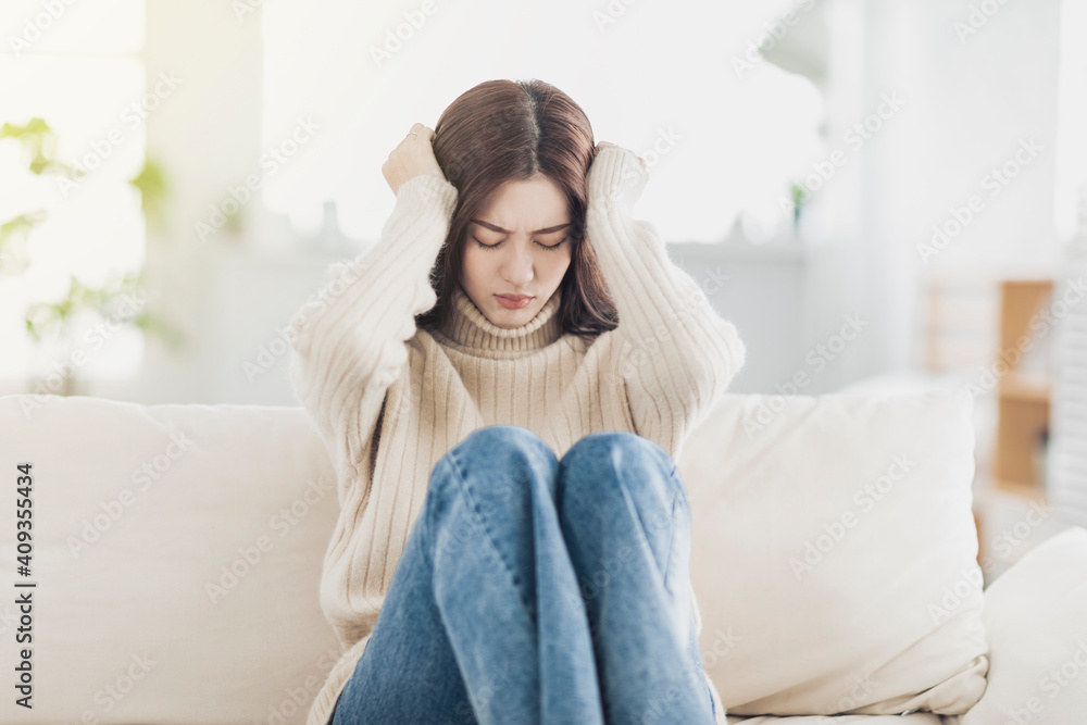 Upset young woman sit on couch at home feel lonely Upset young woman sit on couch at home feel lonely