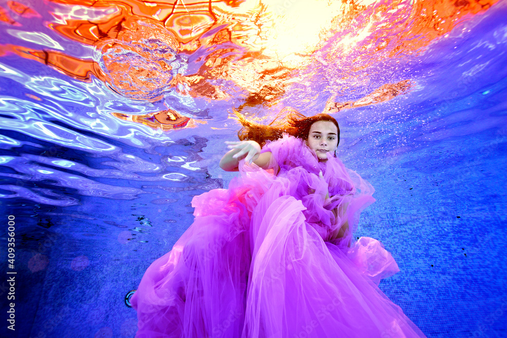 A creative portrait of a young girl in a luxurious pink dress, who ...