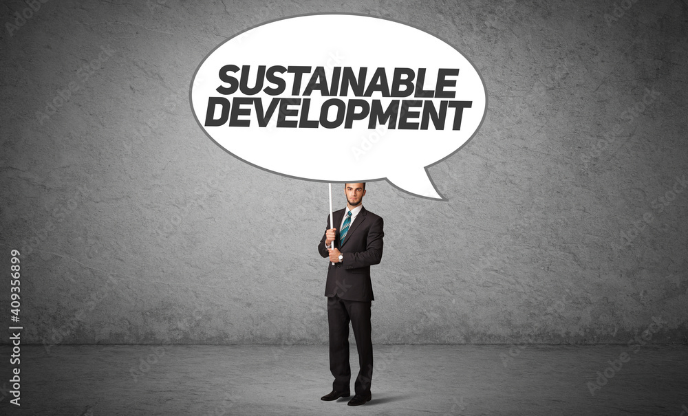 Young business person in casual holding road sign with SUSTAINABLE DEVELOPMENT inscription, new business idea concept Young business person in casual holding road sign with SUSTAINABLE DEVELOPMENT inscription, new business idea concept