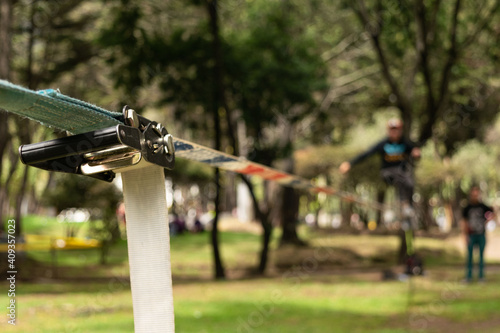 Hombre desenfocado haciendo equilibrio sobre una correa de nylon practicando Slacklining