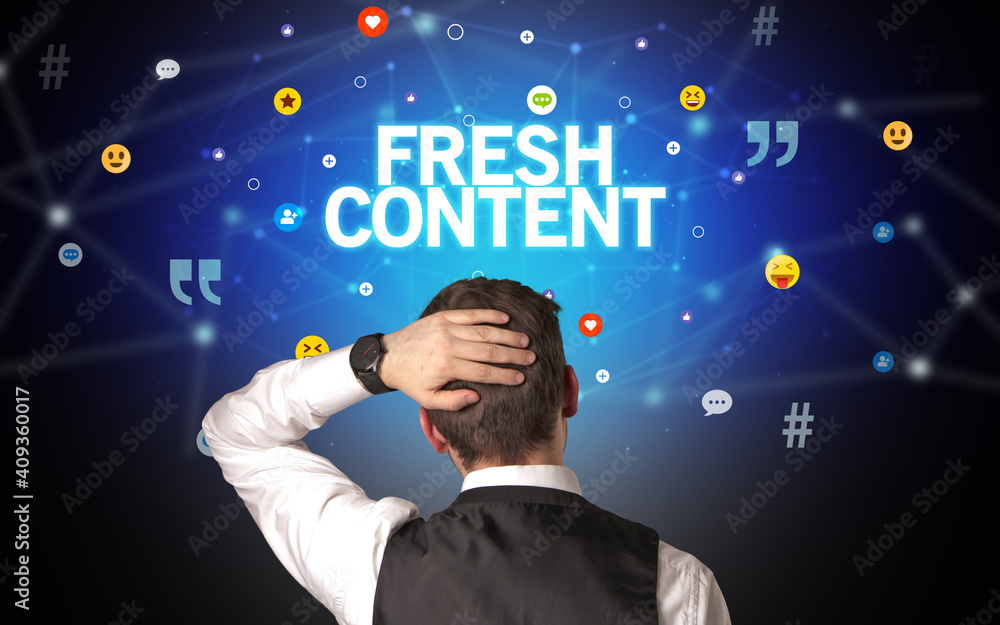 Rear view of a businessman with FRESH CONTENT inscription, social networking concept Rear view of a businessman with FRESH CONTENT inscription, social networking concept