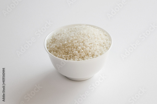 rice grains in a bowl isolated on white background.