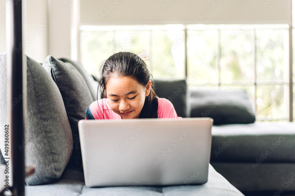 Naklejka premium School kid little girl learning and looking at laptop computer making homework studying knowledge with online education e-learning system.children video conference with teacher tutor at home