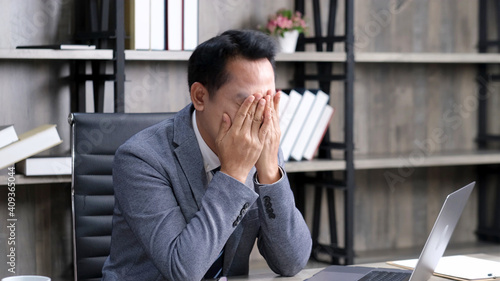 Asian businessman with frustrated and depressed expression while working office desk, office lifestyle