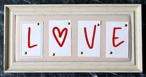 Happy valentine’s day concept, Love word on white vintage wooden frame standing on black marble wall background