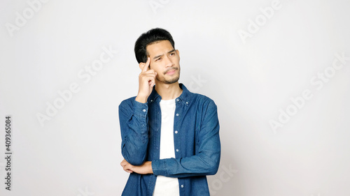 Young asian man doubting while standing over isolated gray background, Portrait of confused handsome asia guy, People negative gusture expression