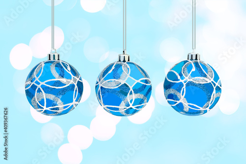 Blue Christmas ornaments isolated on turquoise background with bokeh lights