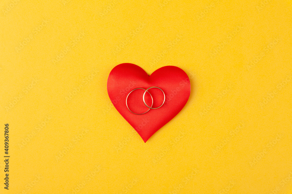 Two jewel round golden rings on red hearts, concept love, gift, proposal of marriage Two jewel round golden rings on red hearts, concept love, gift, proposal of marriage