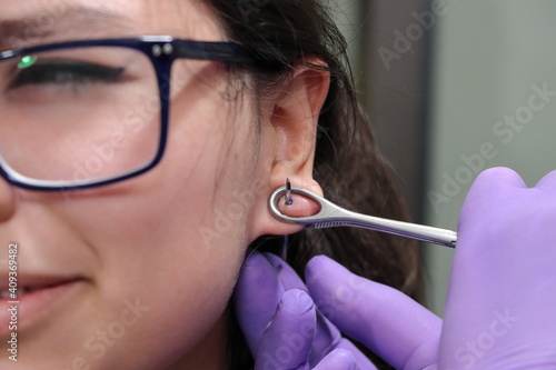 Perforación piercing en oreja lóbulo arete en estudio de tatuajes