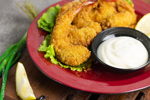 Ebi Furai or Tempura Shrimp or Prawn, Japanese Traditional Cuisine made from Deep Fried Shrimp Coated with Bread Crumb, served with mayounaise sauce, lemon slices, and a bowl of rice with chopstick.   photo