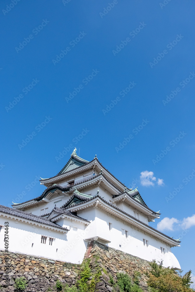 Wakayama, Wakayama Prefecture / Japan, October 15 2020: Low angle view of Wakayama castle with a nearly cloudless blue sky on an early autumn day. Wakayama, Wakayama Prefecture / Japan, October 15 2020: Low angle view of Wakayama castle with a nearly cloudless blue sky on an early autumn day.