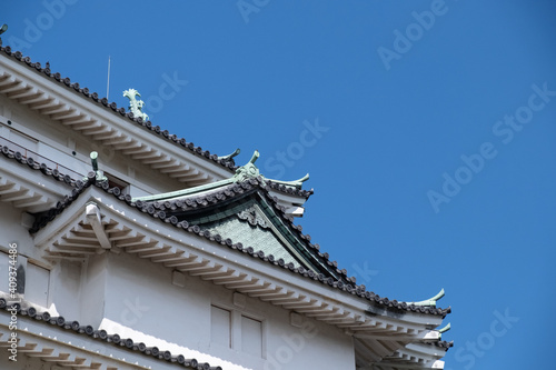 Wakayama  Wakayama Prefecture   Japan  October 15 2020  Close-up low angle view of Wakayama Castle tiled roof and a clear blue sky.