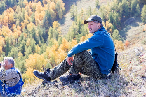 portrait of a mature tourist traveling along the Nurali ridge in the Ural mountains on an autumn sunny day. photo