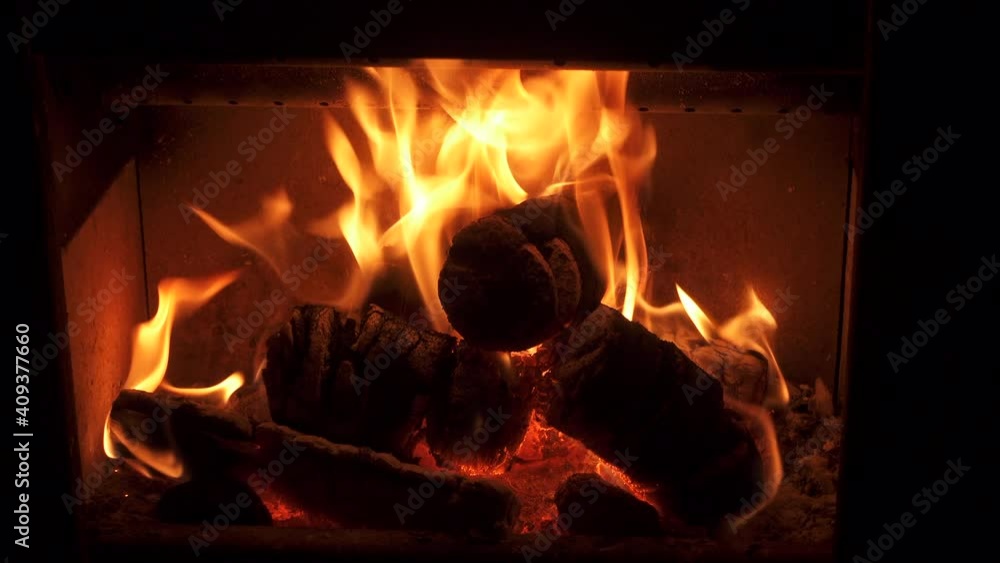 Wood burner stove with wood fire burning brightly. A roaring fire