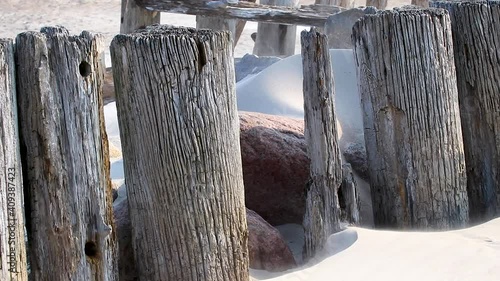 The ruins of an old pier covered with sand. Baltic sea beach near Sventoji village. Sand blow on vindy summer day.  photo