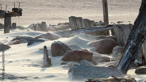 The ruins of an old pier covered with sand. Baltic sea beach near Sventoji village. Sand blow on vindy summer day.  photo