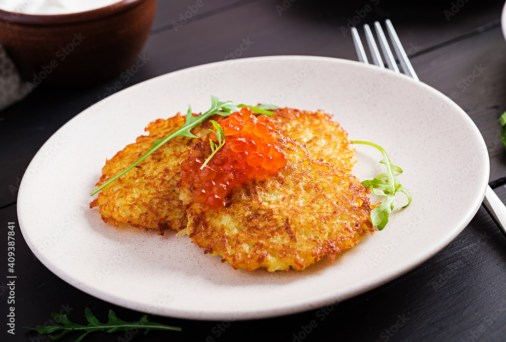 Fried potato pancakes with red caviar and sour cream, fritter, roesti. Traditional delicious food, lunch. Fried potato pancakes with red caviar and sour cream, fritter, roesti. Traditional delicious food, lunch.