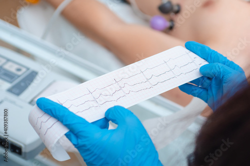 Heart cardiogram in the hands of a doctor close-up. Cardiologist is studying the testimony of an electrocardiograph.