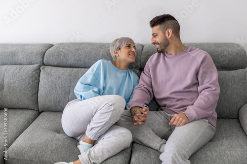  Happy Young Couple is Lying on a New Couch in the Living Room and Having a Rest. Bright Modern Apartment with Stylish Furniture © Juan