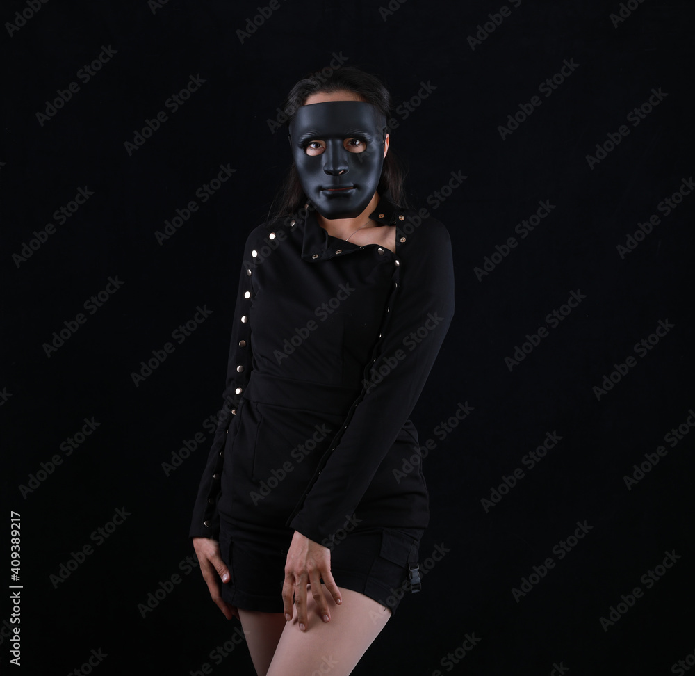 portrait of a girl in a black halloween mask on a black background