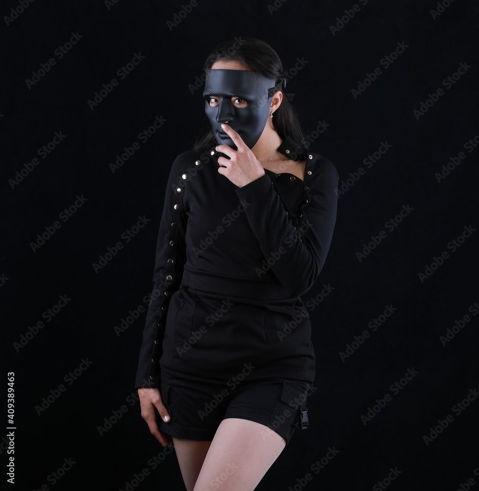portrait of a girl in a black halloween mask on a black background portrait of a girl in a black halloween mask on a black background