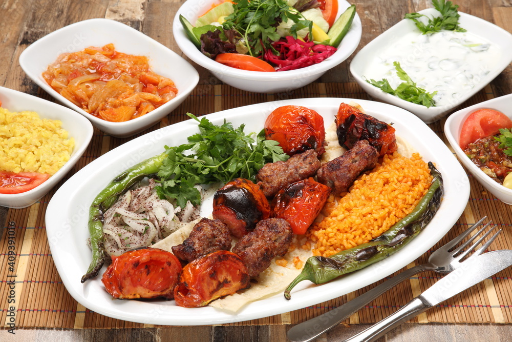Turkish kebab with tomatoes served with grilled tomato pepper and onion Turkish kebab with tomatoes served with grilled tomato pepper and onion