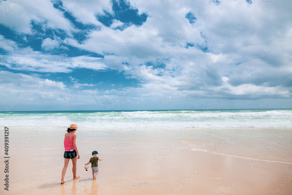 Mother and son walking on the beach Mother and son walking on the beach