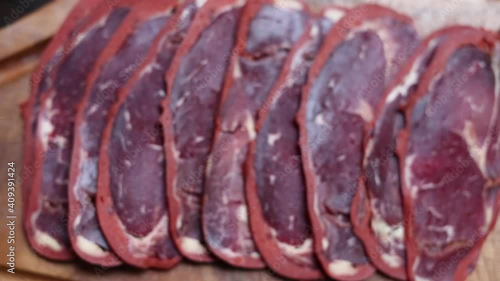 beef bacon sliced ​​on wood board. blurry background. traditional turkish food pastirma