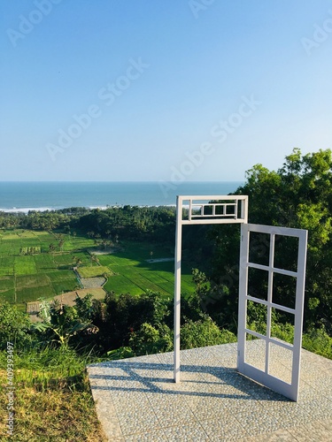 White Doors with Views of the Sea and Green Trees