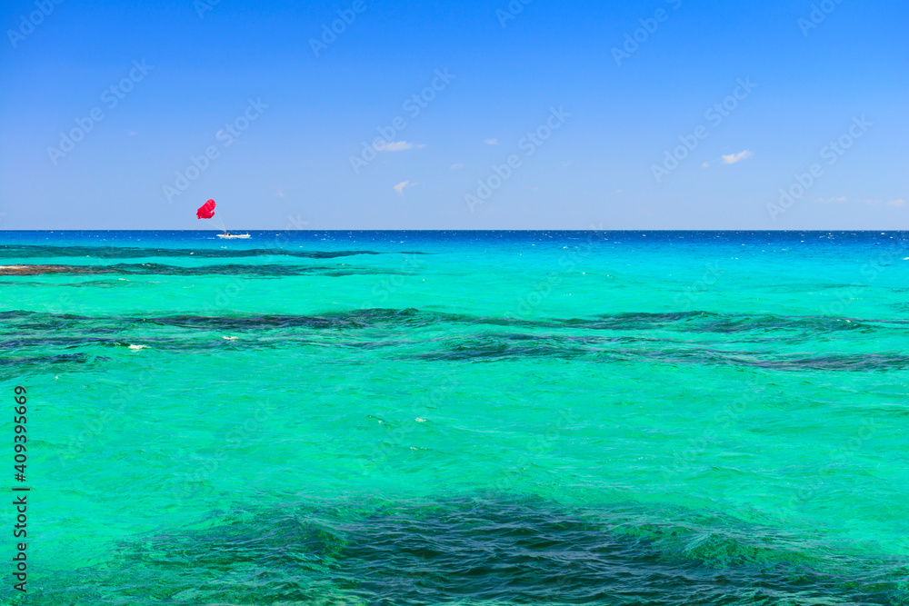Parasailing on a red parachute on the beautiful azure sea Parasailing on a red parachute on the beautiful azure sea